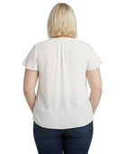 Person wearing a white blouse and blue jeans on a white background