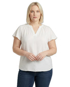 Woman wearing a white blouse and blue jeans on a white background