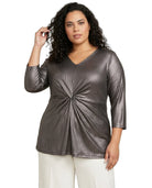 Woman wearing a metallic gray top with a knot detail on a white background