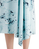 A close-up of a light blue skirt with an abstract black and white marble print, shown on a model against a white background.