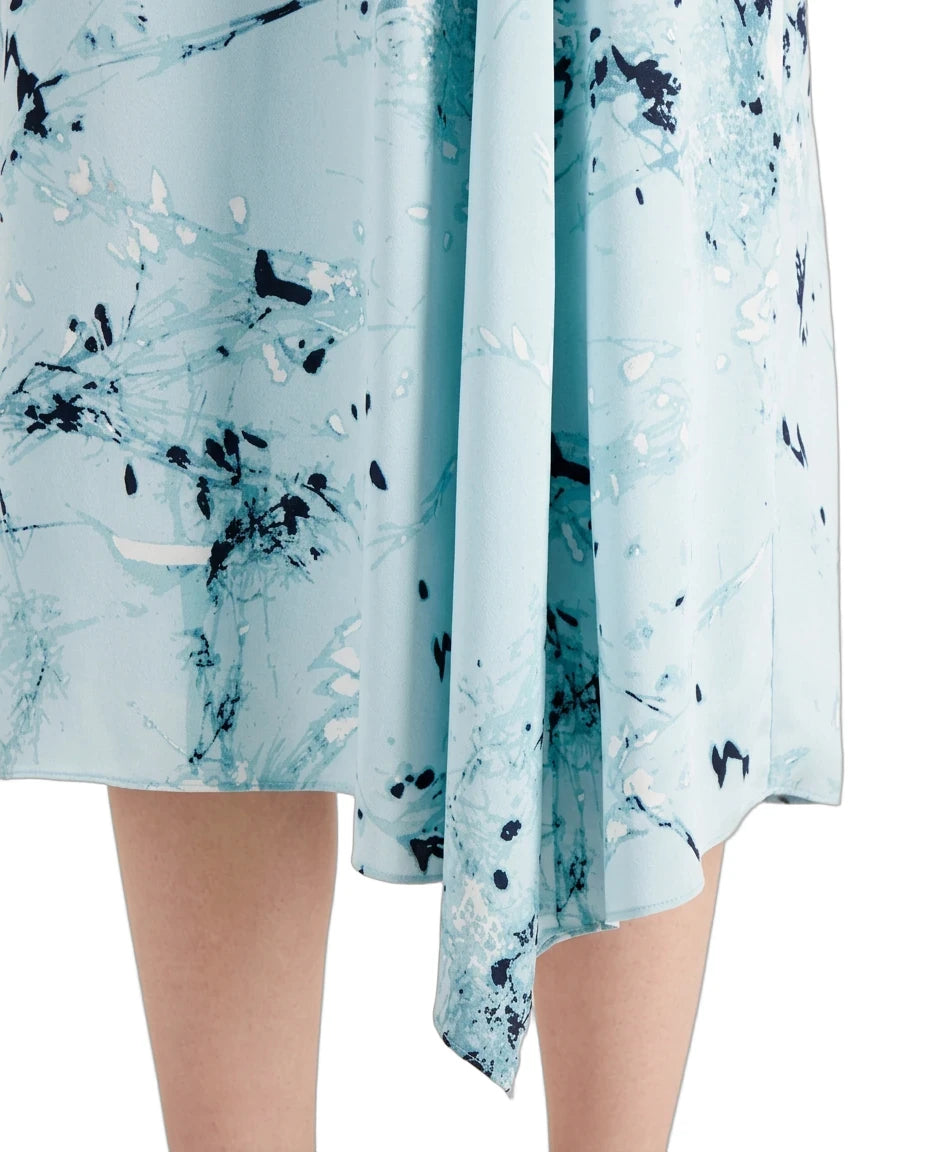 A close-up of a light blue skirt with an abstract black and white marble print, shown on a model against a white background.