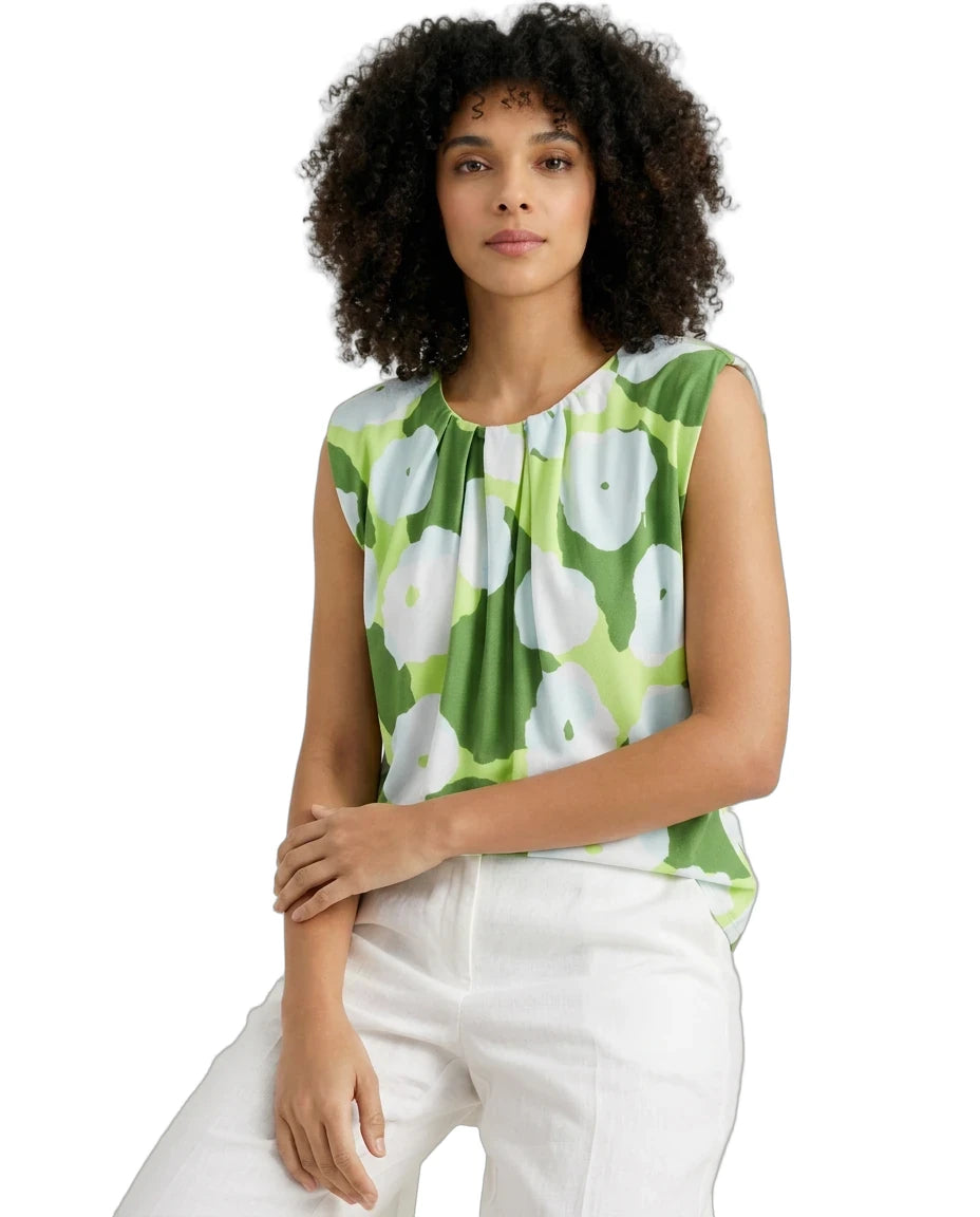 Woman wearing a green floral sleeveless top on a white background