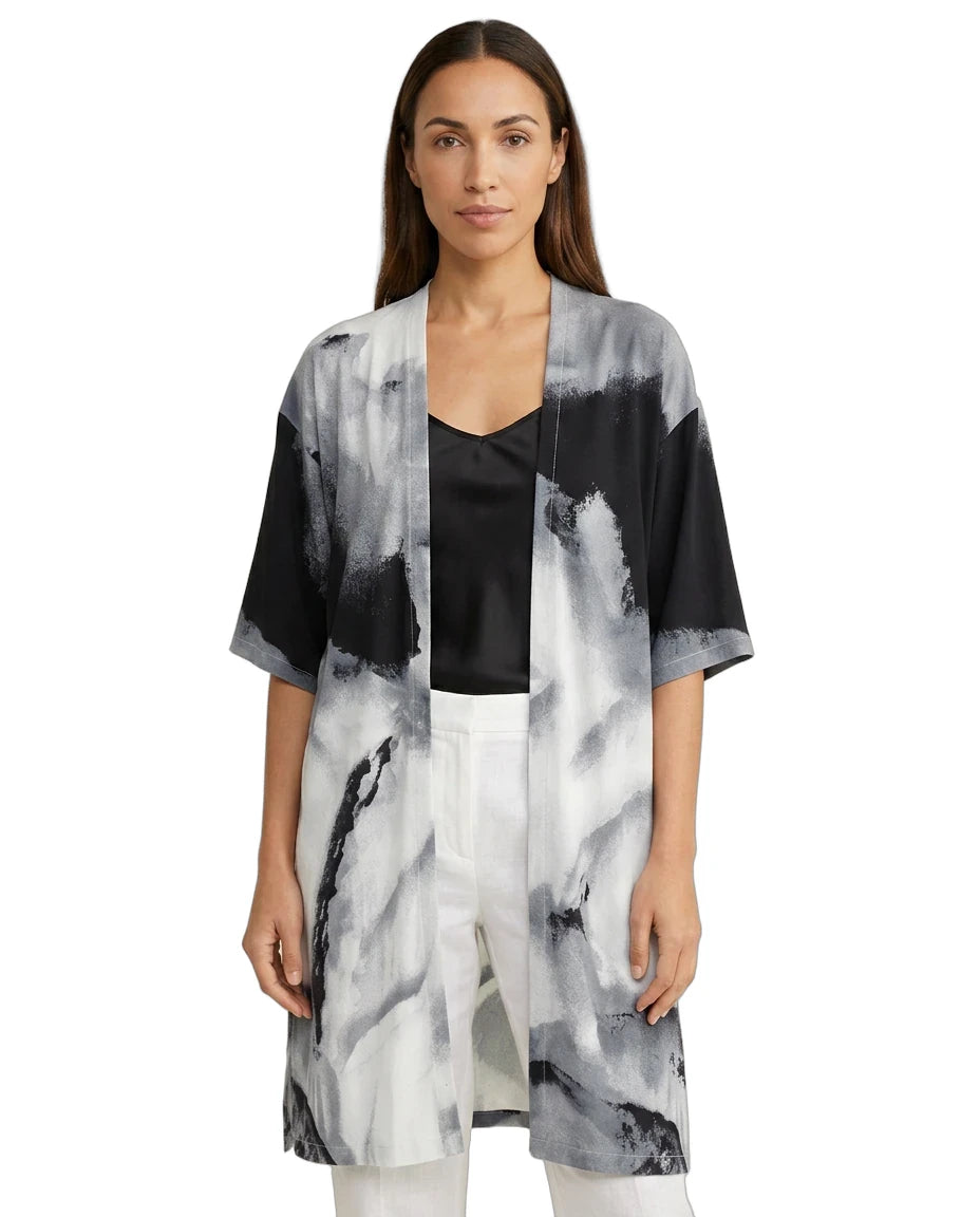 Woman wearing a black, white, and gray abstract patterned kimono-style jacket on a white background