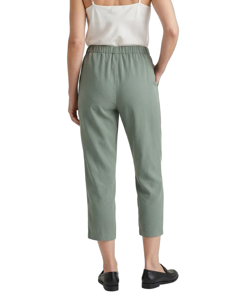 A model shown from the back wearing sage green cropped trousers, a white camisole top, and black loafers against a plain white background.