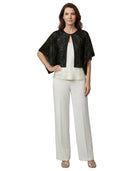 Woman wearing a black sequin top and white pants on a white background