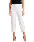 White cropped ankle-length pants shown on a model against a plain white studio background. The model is also wearing a black top and beige heels.