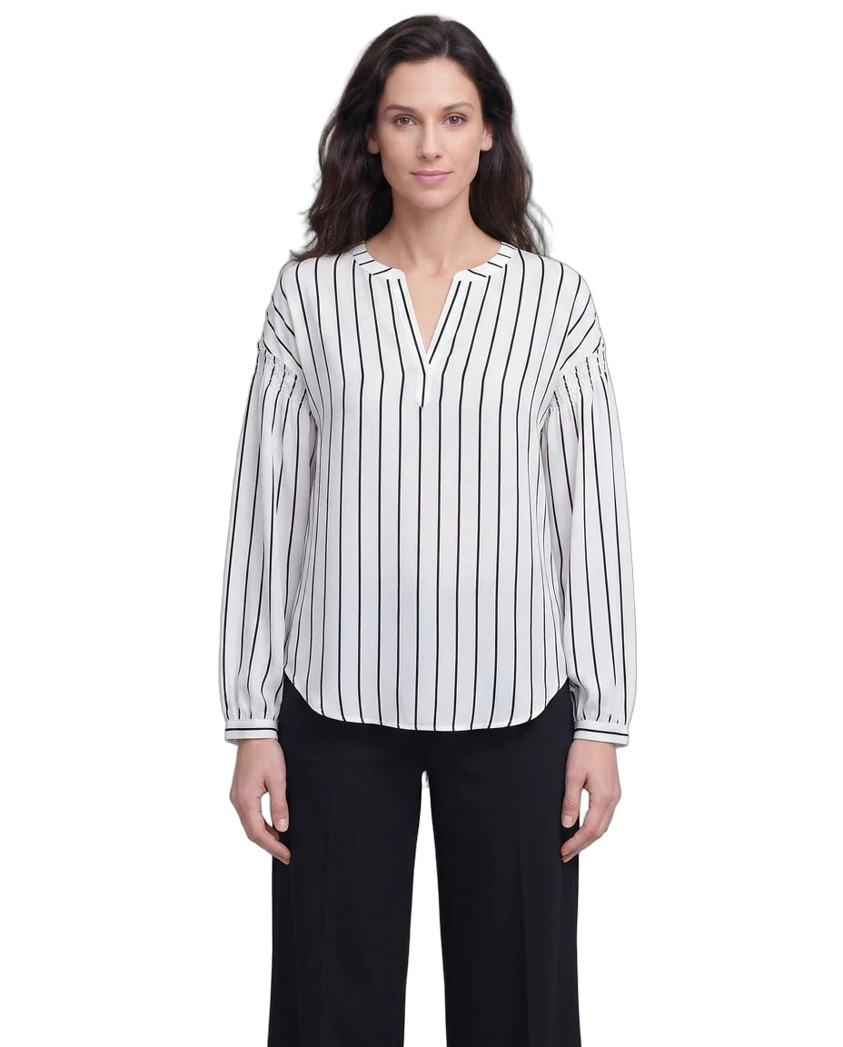 Woman wearing a black and white striped blouse with a plain background