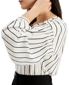 Woman wearing a white blouse with black striped pattern