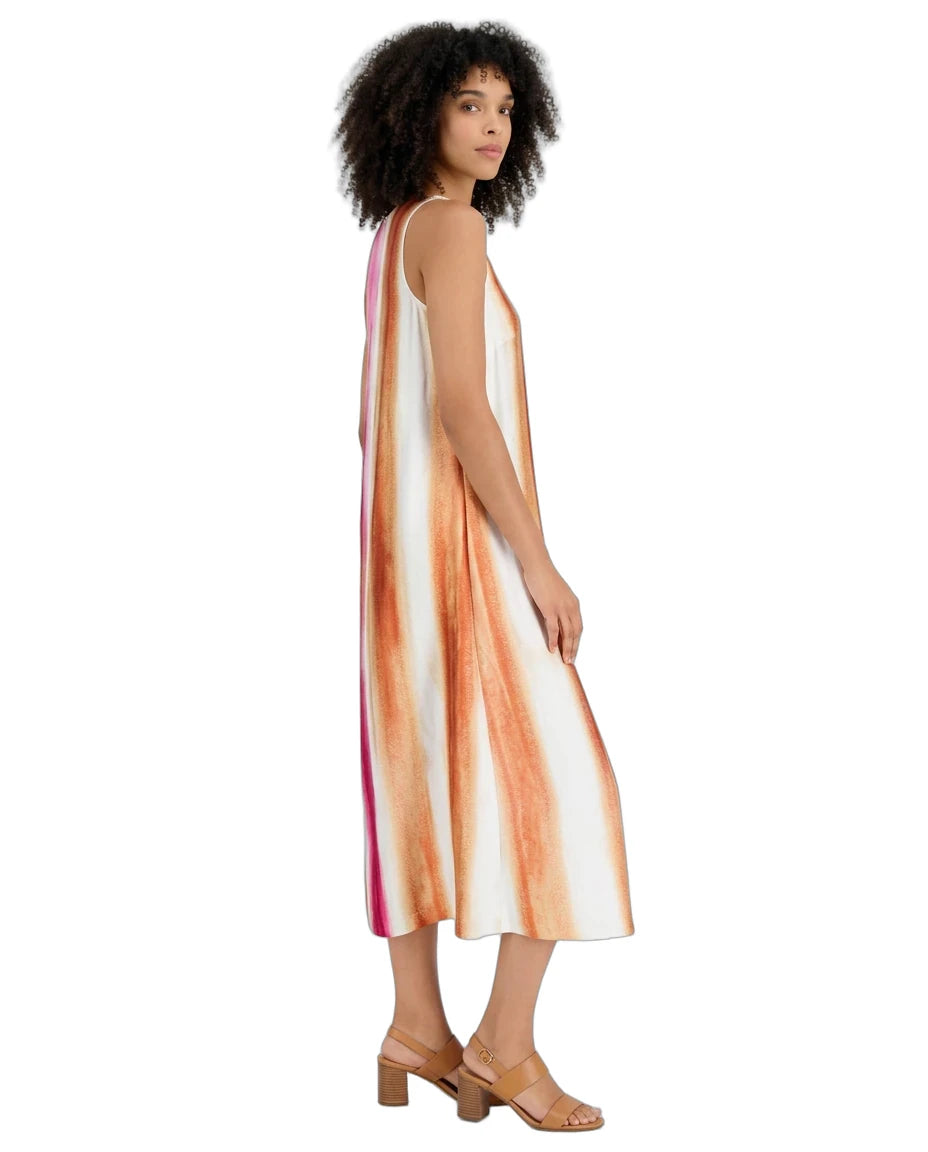 A woman modeling a sleeveless midi dress with vertical orange, peach, and pink watercolor-style stripes on a white base, shown from a side-back angle against a plain white background.