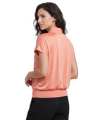Woman wearing a peach-colored short-sleeve blouse on a white background