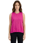 Woman wearing a bright pink sleeveless top on a white background