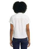 Person wearing a white blouse and dark blue jeans on a white background
