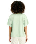 Person wearing a light green t-shirt on a white background