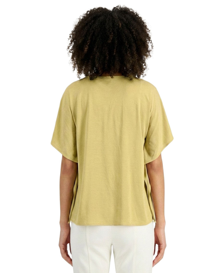 Person wearing a light green t-shirt and white pants on a white background