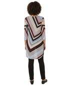 Person wearing a patterned tunic with a white background
