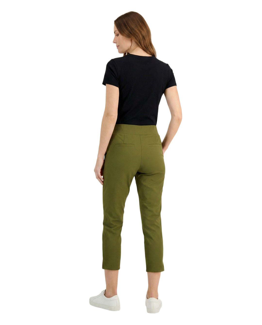 Woman wearing green pants and a black top on a white background