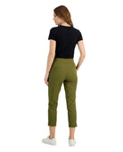 Woman wearing green pants and a black top on a white background