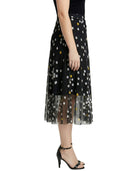 Black tulle skirt with white polka dots worn by a person on a white background