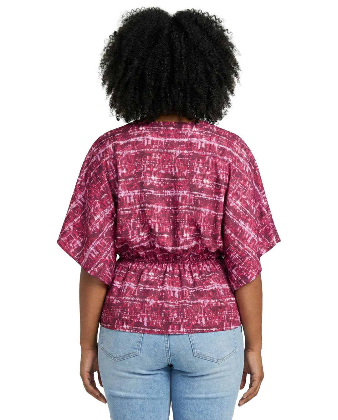 Person wearing a red and white patterned blouse with blue jeans on a white background