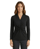 Woman wearing a black long-sleeve top with a knot detail on a white background