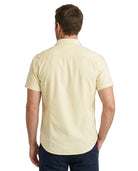 Man wearing a light yellow short-sleeve shirt on a white background