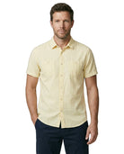 Man wearing a light yellow short-sleeve shirt on a white background