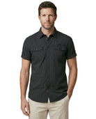 Man wearing a black short-sleeve shirt with pockets on a white background