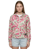 Person wearing a pink and beige camouflage jacket with a brand logo on a white background