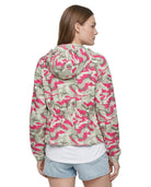Woman wearing a pink and green camouflage jacket on a white background