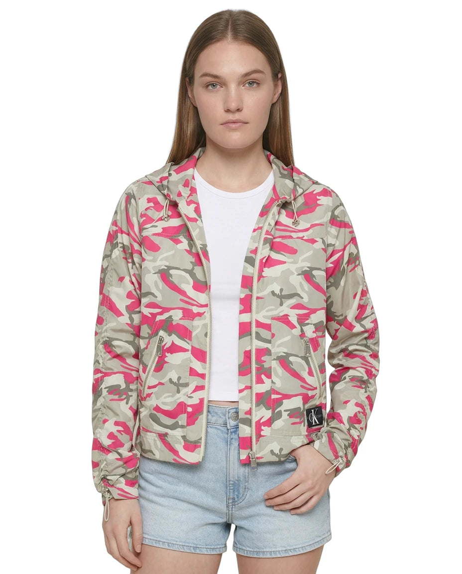 Person wearing a pink and green camouflage jacket on a white background