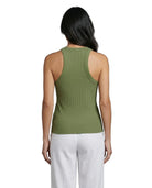 Woman wearing a green tank top and white pants on a white background