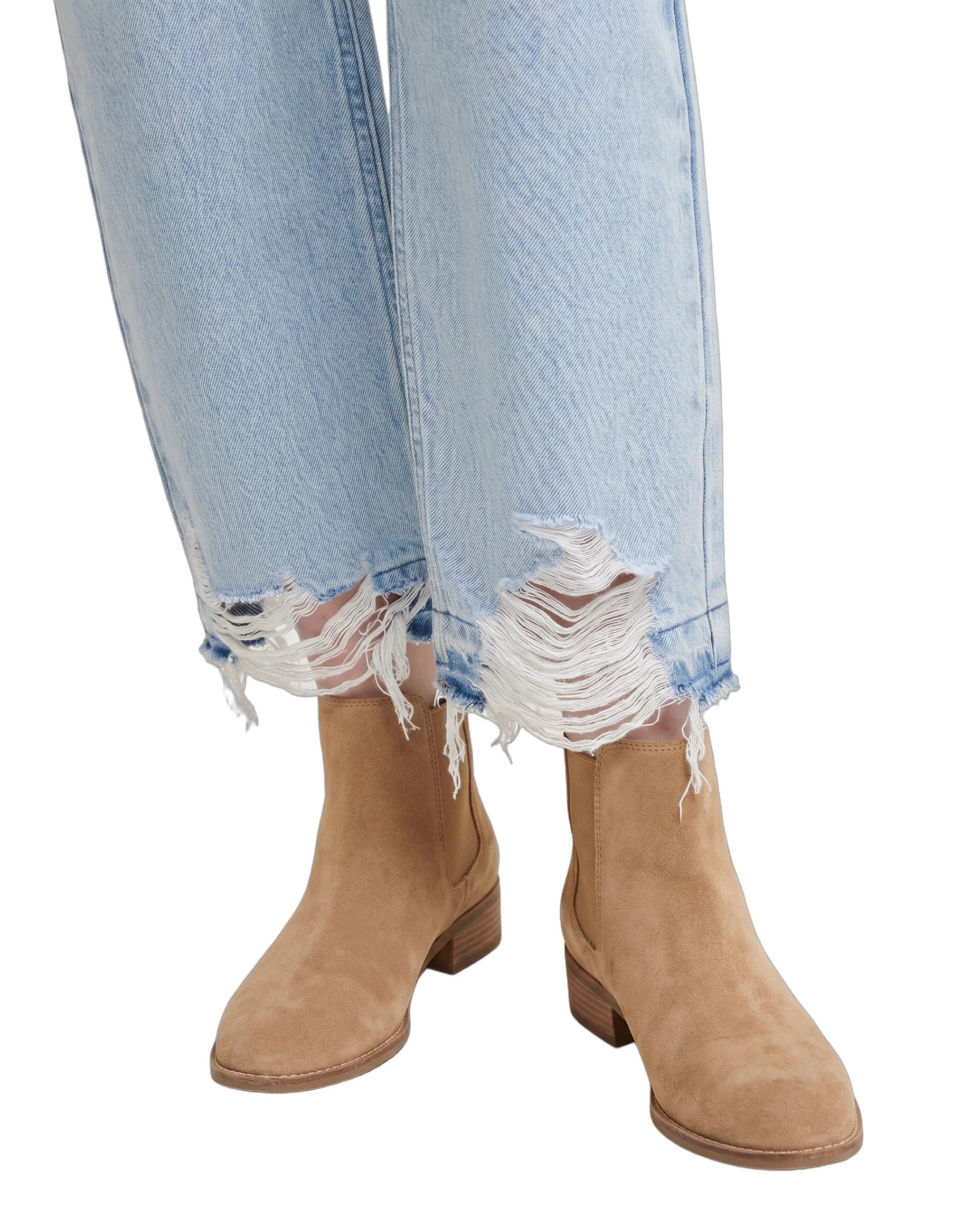 Tan ankle boots worn with light blue jeans on a white background