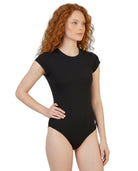 Woman wearing a black bodysuit on a white background