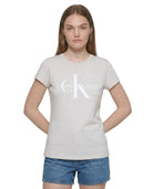 Person wearing a Calvin Klein t-shirt and denim shorts on a white background