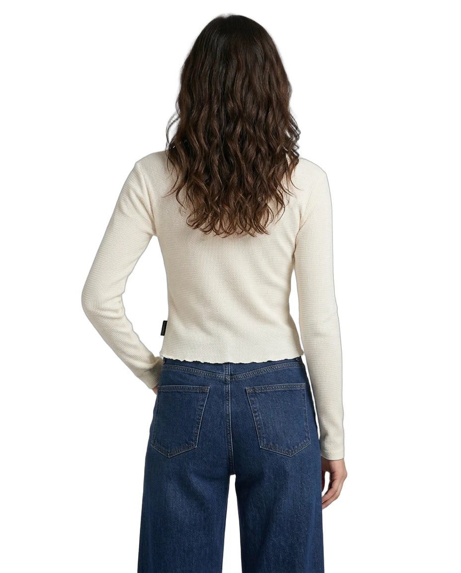 Person wearing a cream sweater and blue jeans on a white background