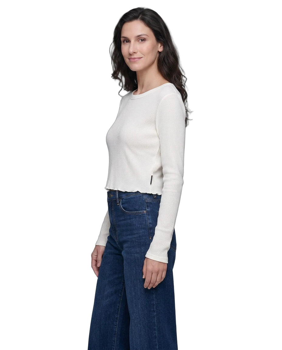 Woman wearing a white long-sleeve top and blue jeans on a white background
