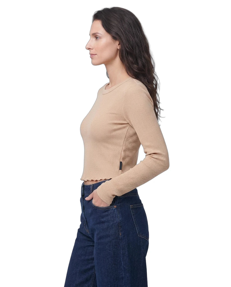 Woman wearing a beige sweater and blue jeans on a white background