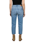 Person wearing blue jeans and brown boots on a white background