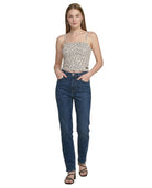 Woman wearing a leopard print top and blue jeans on a white background