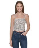 Woman wearing a patterned crop top and jeans on a white background