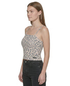 Woman wearing a leopard print top and black pants on a white background