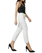 Woman wearing a black top and white pants on a white background