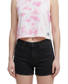 Person wearing a pink tie-dye crop top and black shorts on a white background
