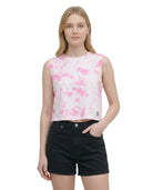 Woman wearing a pink tie-dye sleeveless top and black shorts on a white background