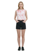 Woman wearing a sleeveless floral top and black shorts on a white background