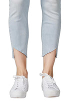 White sneakers worn with light blue pants on a white background