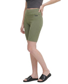 Person wearing green capri pants on a white background