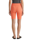 Person wearing bright orange shorts on a white background