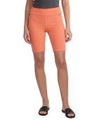 Person wearing orange shorts on a white background