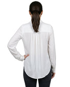 Woman wearing a white blouse with a subtle pattern on a white background